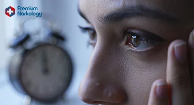 Глаз девушки рядом с будильником